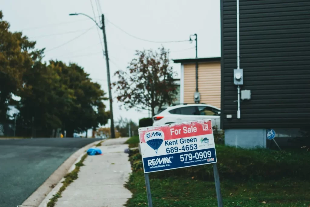 Printed advertising board on a lawn beside a sidewalk