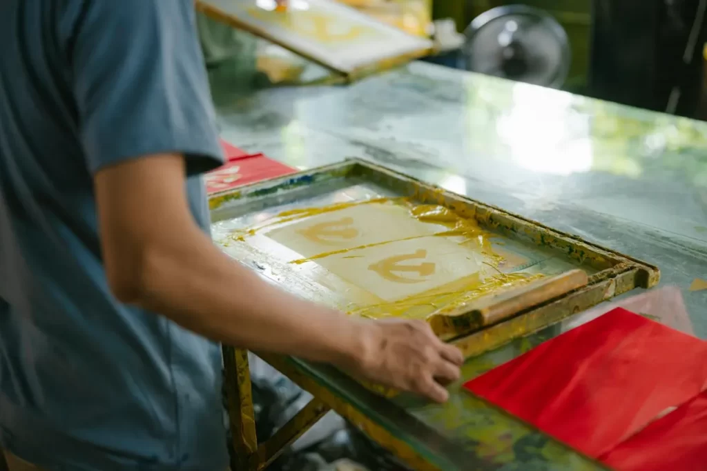 Screen printer pulling ink through a silkscreen frame